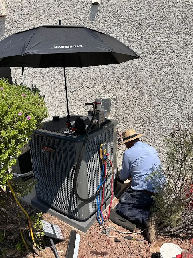HVAC technician performing outdoor AC maintenance in Ross